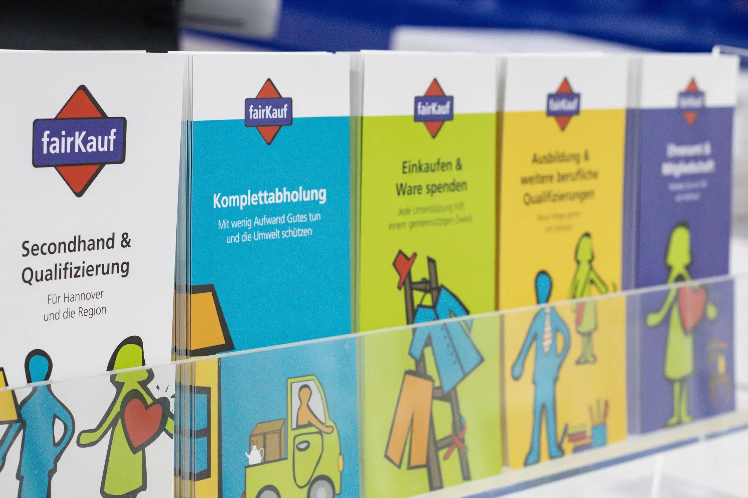 fairKauf-Infobroschüren zu Secondhand, Abholung, Spenden, Qualifizierung und Ehrenamt im Display.
