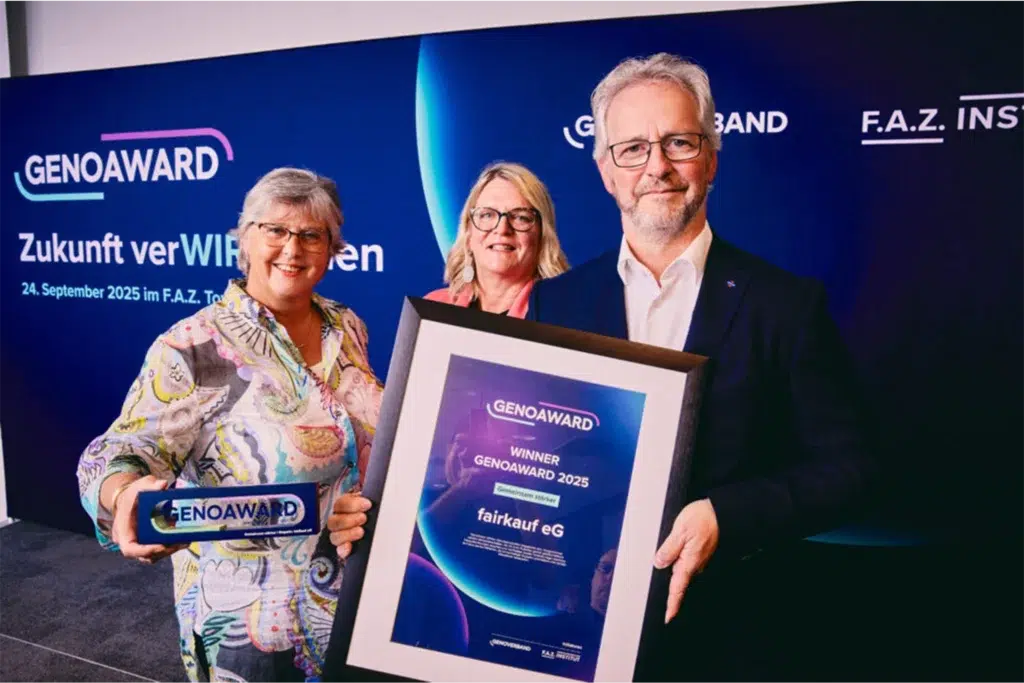 Drei Personen präsentieren eine Auszeichnung und eine Urkunde beim GenoAward-Event.